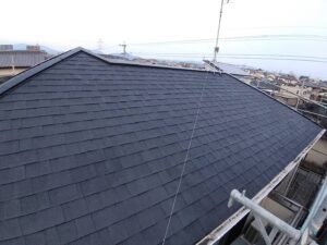 新居浜市で屋根塗装の上塗り作業を行う様子